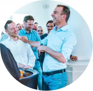 Groep mannen in zakelijke kleding die lachen en plezier maken.