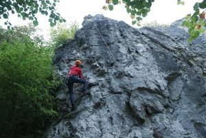 Persoon in een rood shirt aan het bergbeklimmen.